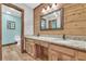 The bathroom boasts a wood accent wall, double sinks, and a granite countertop at 3208 Paddock Rd, Covington, GA 30014
