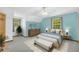 Bright bedroom with a ceiling fan, light blue accent wall, and large windows that let in natural light at 3208 Paddock Rd, Covington, GA 30014