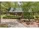 Charming log cabin with a covered porch, surrounded by lush greenery and well-maintained landscaping at 3208 Paddock Rd, Covington, GA 30014