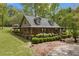 Charming log cabin home with a covered porch and mature landscaping in a serene setting at 3208 Paddock Rd, Covington, GA 30014