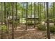 Secluded log home and detached garage surrounded by mature trees and lush greenery at 3208 Paddock Rd, Covington, GA 30014
