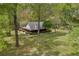 Aerial view of log home surrounded by trees and well-maintained lawn at 3208 Paddock Rd, Covington, GA 30014