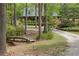 Quaint log cabin with bridge over small ravine and landscaped yard nestled among mature trees at 3208 Paddock Rd, Covington, GA 30014