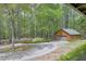 Detached log garage with a paved driveway and well-maintained landscaping at 3208 Paddock Rd, Covington, GA 30014