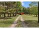 Scenic view of the grounds leading to the red outbuilding, surrounded by trees and greenery at 3208 Paddock Rd, Covington, GA 30014