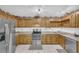 Well-lit kitchen featuring knotty pine cabinets, tile floor, and stainless steel appliances at 3208 Paddock Rd, Covington, GA 30014