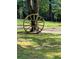 Rustic antique wagon wheel adorns a shady yard among the trees at 3208 Paddock Rd, Covington, GA 30014