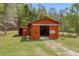 Red outbuilding/storage shed with open bay and traditional doors on a grassy lawn at 3208 Paddock Rd, Covington, GA 30014