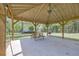 Covered picnic area with a concrete slab, featuring a wooden picnic table and a grill at 3208 Paddock Rd, Covington, GA 30014