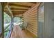 Relaxing porch with a swing, wood flooring, and rustic log cabin details, perfect for enjoying the outdoors at 3208 Paddock Rd, Covington, GA 30014