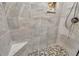 Shower with beige tiling, pebble flooring, and accent tile niche at 3208 Paddock Rd, Covington, GA 30014