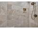 Shower with beige tiling, pebble flooring, and accent tile niche at 3208 Paddock Rd, Covington, GA 30014
