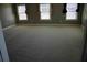 Spacious bedroom with three windows bringing in natural light and plush carpet at 2616 Holden Spring Dr, Dacula, GA 30019