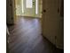 A hallway showcasing gorgeous dark hardwood flooring, leading to the foyer with lots of natural light at 2616 Holden Spring Dr, Dacula, GA 30019