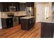 Well-equipped kitchen boasts dark cabinetry, stainless appliances, granite countertops, and a kitchen island at 2616 Holden Spring Dr, Dacula, GA 30019