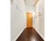 Hallway with hardwood floors leading to a front door and artwork on the walls at 923 Peachtree Ne St # 927, Atlanta, GA 30309