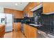 Kitchen featuring stainless steel appliances, tile backsplash, wood cabinets, and wood flooring at 923 Peachtree Ne St # 927, Atlanta, GA 30309