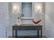 Stylish entryway featuring textured wallpaper, a modern console table, decorative objects, and sconce lighting at 1065 Peachtree Ne St # 3003, Atlanta, GA 30309