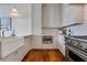 Well-lit kitchen with hardwood floors, farmhouse sink, stainless steel appliances, and white cabinets at 1065 Peachtree Ne St # 3003, Atlanta, GA 30309