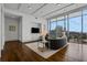 Elegant living room featuring floor-to-ceiling windows, hardwood floors, city views, and built-in entertainment center at 1065 Peachtree Ne St # 3003, Atlanta, GA 30309