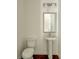 Powder room featuring pedestal sink, square mirror, three-light vanity fixture, and dark hardwood floors at 2029 Memorial Dr # 34, Atlanta, GA 30317