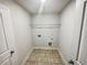 Functional laundry room featuring tile floors, a utility sink, and storage shelf at 3650 Lindsy Brooke Ct, Douglasville, GA 30135