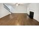 Spacious living room with hardwood floors, a fireplace, a ceiling fan, and stairs leading to the upper floor at 3650 Lindsy Brooke Ct, Douglasville, GA 30135
