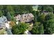 Aerial view of a brick home surrounded by mature trees and lush landscaping at 858 Middle Fork Trl, Suwanee, GA 30024