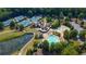 Aerial view of community clubhouse, tennis courts, pool, and pond surrounded by lush greenery at 858 Middle Fork Trl, Suwanee, GA 30024