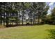 Manicured backyard with mature trees offers privacy and scenic golf course views at 858 Middle Fork Trl, Suwanee, GA 30024