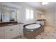 Luxurious bathroom features a jacuzzi tub, granite countertops, and custom cabinetry at 858 Middle Fork Trl, Suwanee, GA 30024