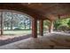 Covered patio featuring brick arches, stone floor, and scenic views of the backyard and golf course at 858 Middle Fork Trl, Suwanee, GA 30024