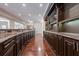Long curved bar with dark wood cabinets and granite top in finished basement at 3133 Saint Ives Country Club Pkwy, Johns Creek, GA 30097
