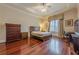 Well-lit bedroom with hardwood floors and a dresser at 3133 Saint Ives Country Club Pkwy, Johns Creek, GA 30097