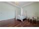 Light and airy bedroom with hardwood floors, a canopy bed, and a writing desk at 3133 Saint Ives Country Club Pkwy, Johns Creek, GA 30097