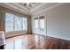 Bedroom with hardwood floors and French doors leading to a balcony at 3133 Saint Ives Country Club Pkwy, Johns Creek, GA 30097