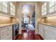 Butlers pantry with wine cooler, granite countertops, and glass-front cabinets at 3133 Saint Ives Country Club Pkwy, Johns Creek, GA 30097