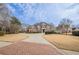 Brick home with circular driveway and manicured lawn at 3133 Saint Ives Country Club Pkwy, Johns Creek, GA 30097