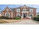 Two-story brick home with landscaped yard at 3133 Saint Ives Country Club Pkwy, Johns Creek, GA 30097