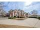 Brick house with a large circular driveway at 3133 Saint Ives Country Club Pkwy, Johns Creek, GA 30097