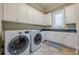 Bright laundry room with white cabinets, granite countertops, and LG washer/dryer at 3133 Saint Ives Country Club Pkwy, Johns Creek, GA 30097