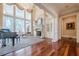 Spacious living room features hardwood floors, fireplace, large windows, and a grand piano at 3133 Saint Ives Country Club Pkwy, Johns Creek, GA 30097