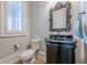 Modern powder room with dark vanity, black granite countertop, and ornate mirror at 3133 Saint Ives Country Club Pkwy, Johns Creek, GA 30097