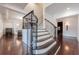 Elegant staircase with wrought iron railing and hardwood floors at 3133 Saint Ives Country Club Pkwy, Johns Creek, GA 30097