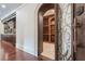 Wine cellar with arched entryway, wooden racks, and stone flooring at 3133 Saint Ives Country Club Pkwy, Johns Creek, GA 30097
