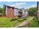 A multi-story condo building shows a combination of brick and Tudor design, accented by well-maintained lawns and green hedges at 6851 Roswell Rd # E1, Atlanta, GA 30328