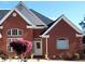 Elegant brick facade with arched windows, a white door, and blooming landscaping at 3240 Somerset Se Ct, Conyers, GA 30013