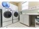 Efficient laundry room with a sink, lots of cabinets, washer, and dryer at 3240 Somerset Se Ct, Conyers, GA 30013