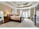 Serene main bedroom featuring tray ceilings, plush carpet, and a private balcony overlooking the backyard at 3240 Somerset Se Ct, Conyers, GA 30013