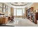 Bright home office with a large window, built-in bookshelves, and a comfortable workspace for productivity at 3240 Somerset Se Ct, Conyers, GA 30013